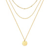 Gold-plated necklace with a pendant, photographed on a jewelry display stand.