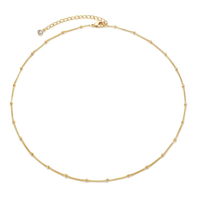 Minimalist gold-plated necklace displayed flat alongside matching earrings.