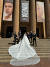 Full-length view of the ELIKA beaded lace mantilla veil draping elegantly over the bride's shoulders.